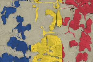 Romania flag depicted in paint colors on old obsolete messy concrete wall closeup. Textured banner on rough background photo