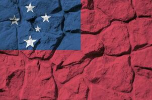 Samoa flag depicted in paint colors on old stone wall closeup. Textured banner on rock wall background photo