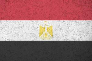 Egypt flag depicted in bright paint colors on old relief plastering wall. Textured banner on rough background photo