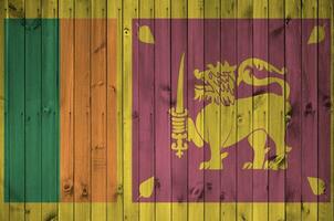 sri lanka bandera representado en brillante pintar colores en antiguo de madera pared. texturizado bandera en áspero antecedentes foto