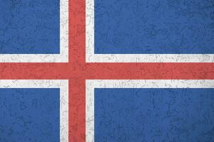 Iceland flag depicted in bright paint colors on old relief plastering wall. Textured banner on rough background photo