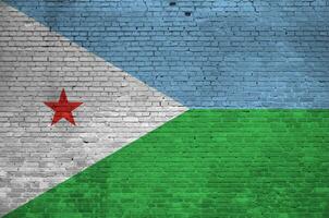 Djibouti flag depicted in paint colors on old brick wall. Textured banner on big brick wall masonry background photo