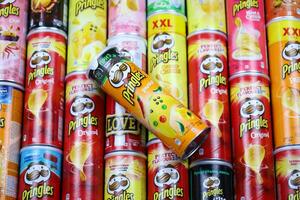 KHARKOV, UKRAINE - MARCH 30, 2021 Many Pringles cylinder chips boxes with varios colors and flavours. American brand of stackable potato-based crisps photo