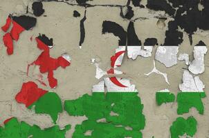 Western Sahara flag depicted in paint colors on old obsolete messy concrete wall closeup. Textured banner on rough background photo