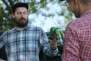 Jarkov, Ucrania - julio 31, 2021 verde estaño latas de heineken pálido lager cerveza en hombres manos foto