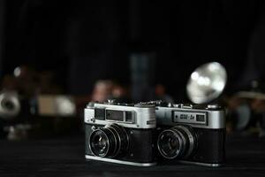 KHARKOV, UKRAINE - APRIL 27, 2021 Fed 4 and 5b Film photo camera and another old retro photo equipment on black wooden table in photographer darkroom. Photographic gear from soviet union