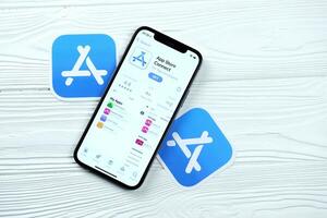 KHARKOV, UKRAINE - MARCH 5, 2021 App store connect icon and application from App store on iPhone 12 pro display screen on white table photo