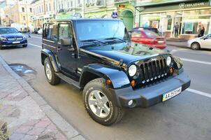 Jeep Wrangler Sahara Black with BFGoodrich All terrain T A tires on Kyiv street photo