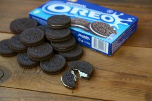 Many OREO sandwich cream biscuits with pack on wooden background photo