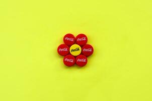 Flower of many red caps with coca cola logo on yellow background photo
