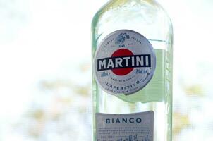 Bottle of Vermouth Martini Rossi close up logo on a green trees background photo