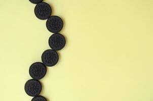 Many OREO sandwich cream biscuits on yellow background photo