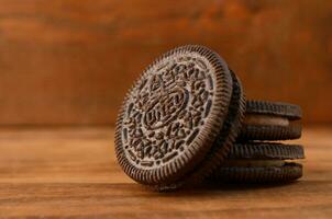 Many OREO sandwich cream biscuits on wooden background photo