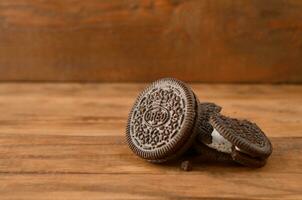 Many OREO sandwich cream biscuits on wooden background photo