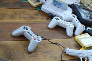 Old 8-bit video game console and many gaming accessories like a joysticks and cartridges photo