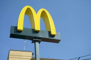 McDonalds yellow big logo on blue sky background photo