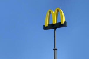 McDonalds yellow big logo on blue sky background photo