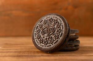 Many OREO sandwich cream biscuits on wooden background photo