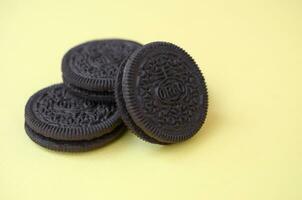 Many OREO sandwich cream biscuits on yellow background photo