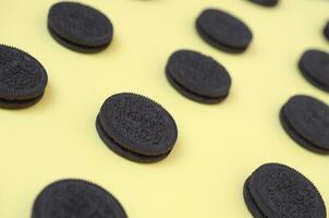 Many OREO sandwich cream biscuits on yellow background photo