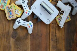 Old 8-bit video game console and many gaming accessories like a joysticks and cartridges photo