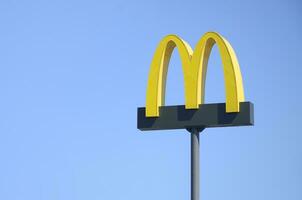McDonalds yellow big logo on blue sky background photo