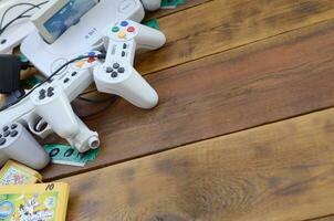 Old 8-bit video game console and many gaming accessories like a joysticks and cartridges photo