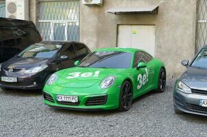 Porsche 911 Carrera 4S in green color with white stickers of Ze Team photo