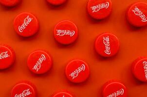 Many red caps with coca cola logo on red background photo