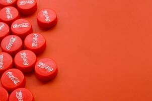 Many red caps with coca cola logo on red background photo