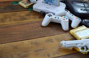 Old 8-bit video game console and many gaming accessories like a joysticks and cartridges photo