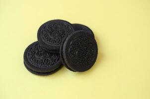 Many OREO sandwich cream biscuits on yellow background photo