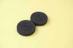 Two OREO sandwich cream biscuits on yellow background photo