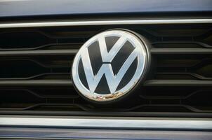 Volkswagen logo in black car front part close up outdoors photo