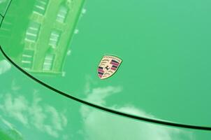 Porsche 911 Carrera 4S in green color with frontal main logo close up photo