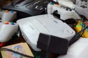 Pile of old 8-bit video game consoles and many gaming accessories like a joysticks and cartridges photo