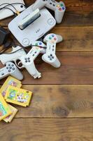 Old 8-bit video game console and many gaming accessories like a joysticks and cartridges photo