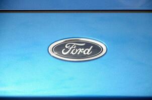 Ford logo in blue car front part close up outdoors photo