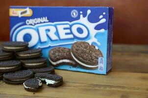 Many OREO sandwich cream biscuits with pack on wooden background photo