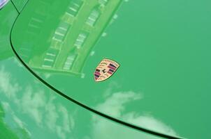 Porsche 911 Carrera 4S in green color with frontal main logo close up photo