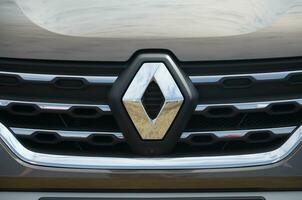 Renault logo in silvery car front part close up outdoors photo