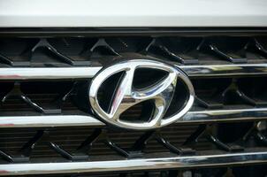 Hyundai logo in white car front part close up outdoors photo