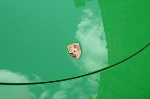 Porsche 911 Carrera 4S in green color with frontal main logo close up photo