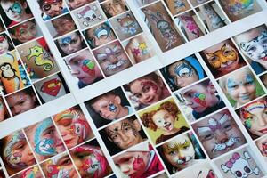 Many catalog pages with printed kids portraits with colorful face painting photo