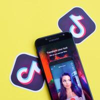 Tik Tok solicitud en Samsung teléfono inteligente pantalla en amarillo antecedentes. Tik Tok es un popular compartir videos social redes Servicio poseído por bytedance foto