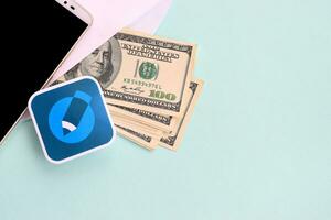 Livejournal paper logo lies with envelope full of dollar bills and smartphone photo