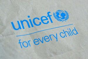 Unicef blue logo on brown paper bag, United Nations Childrens Fund is agency responsible for providing humanitarian and developmental aid to children around the world photo