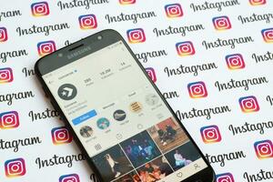 Converse official instagram account on smartphone screen on paper instagram banner. photo