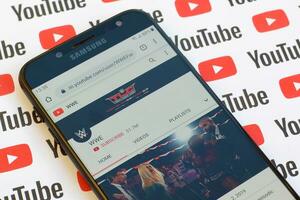 WWE official youtube channel on smartphone screen on paper youtube background. photo