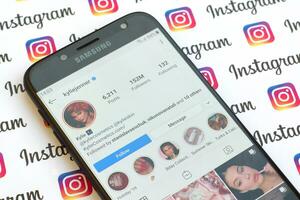 Kylie Jenner official instagram account on smartphone screen on paper instagram banner. photo